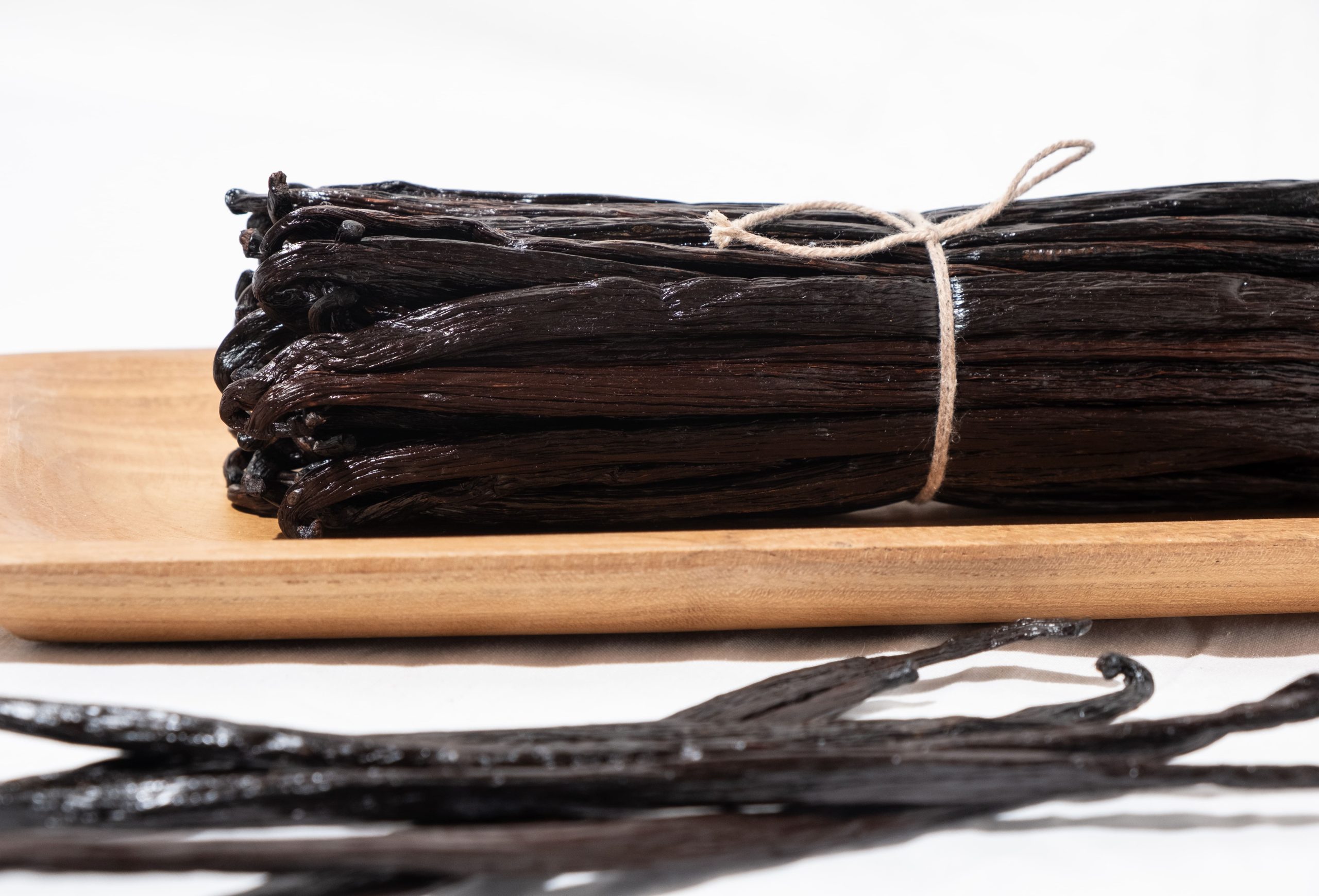 Tahitensis vanilla with a glossy black to dark brown surface and plump appearance.
